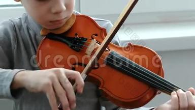 拉<strong>小提琴</strong>。 无法辨认的七岁男孩在拉<strong>小提琴</strong>特写。 前景。